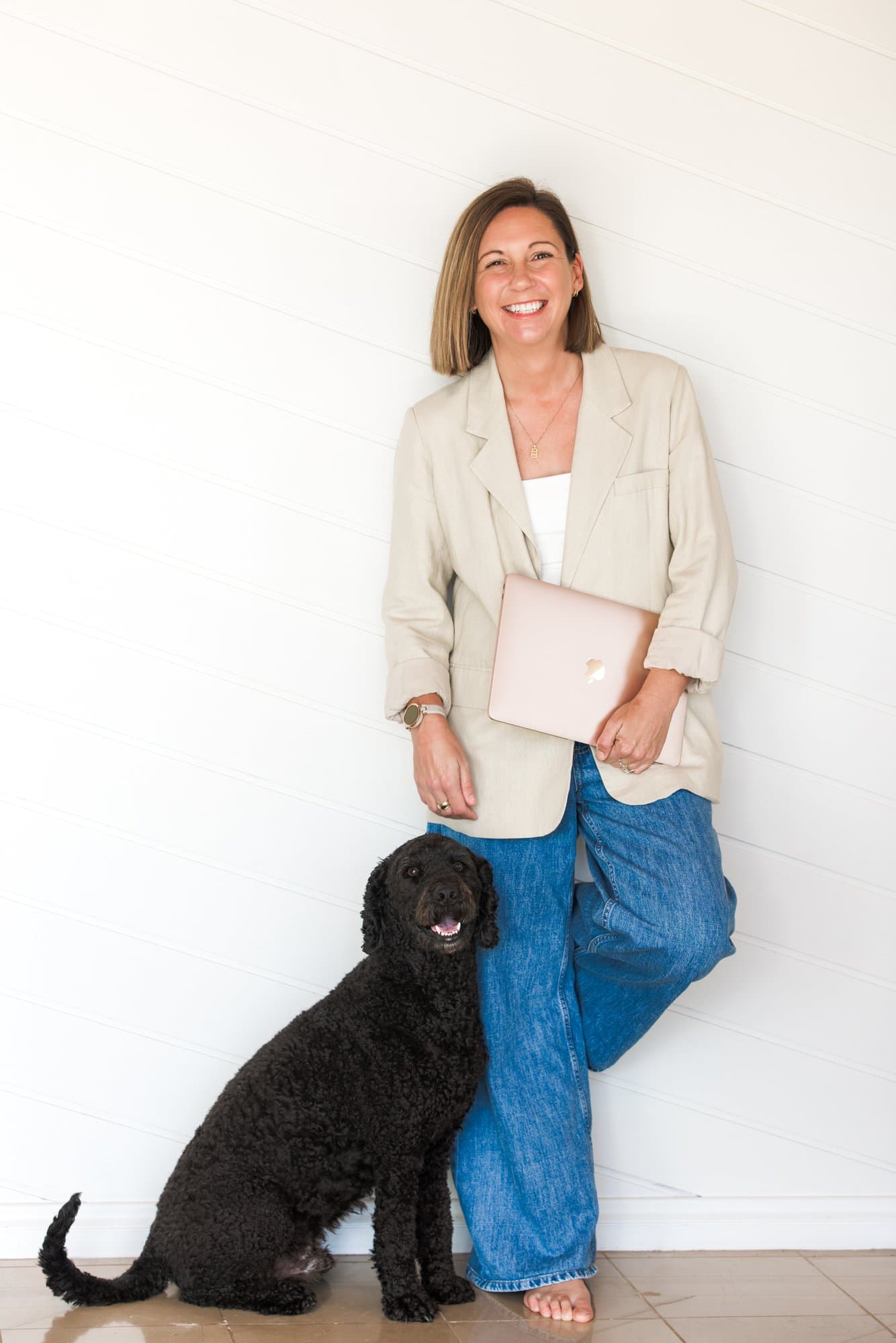 Steph standing with her laptop and dog