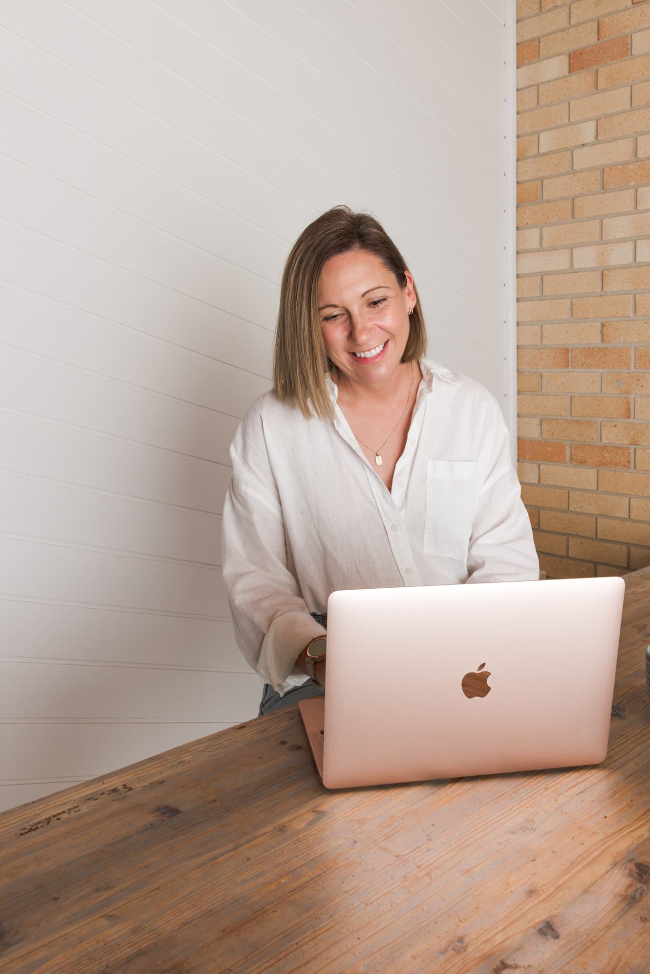 Steph smiling while working on her laptop